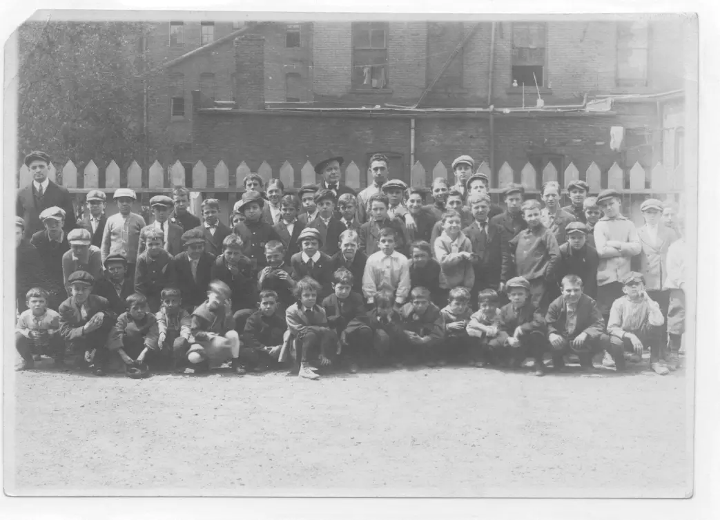 John Gunckel poses with staff members and boys from the Newsboys Association.